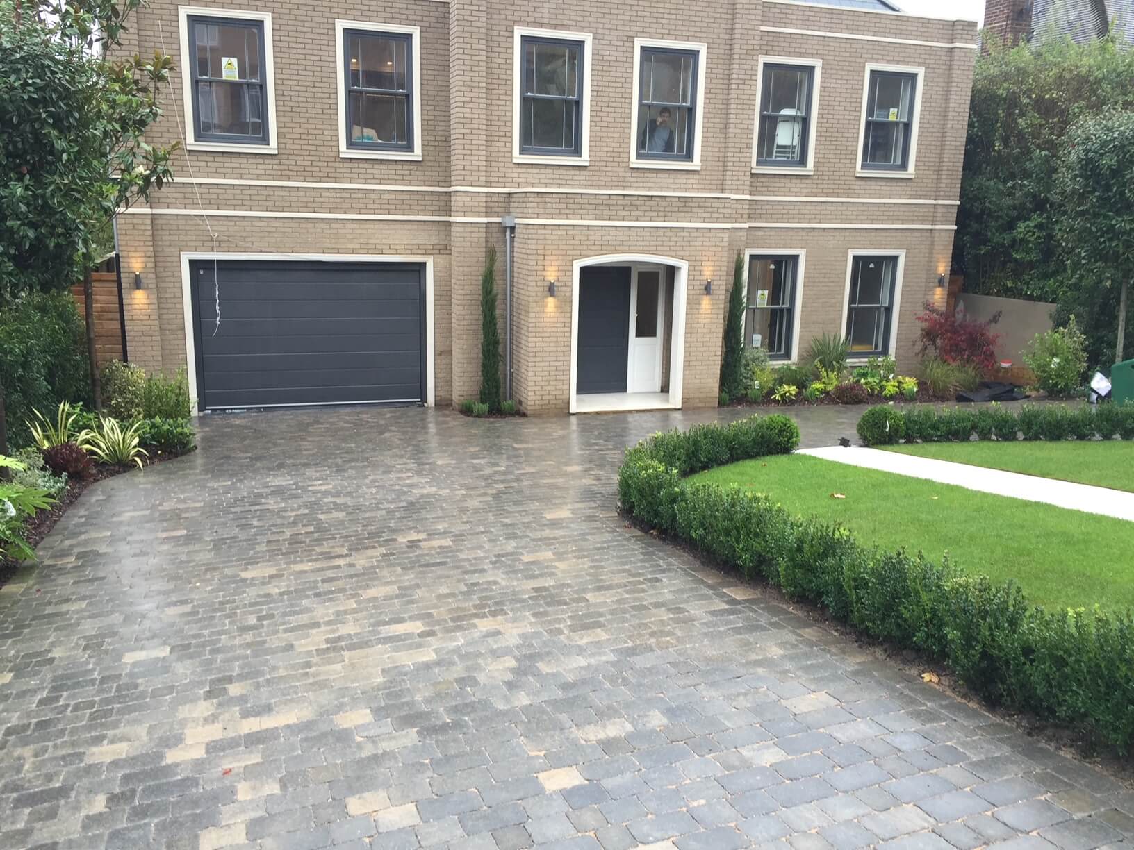 Modern driveway installation in front of a brick house