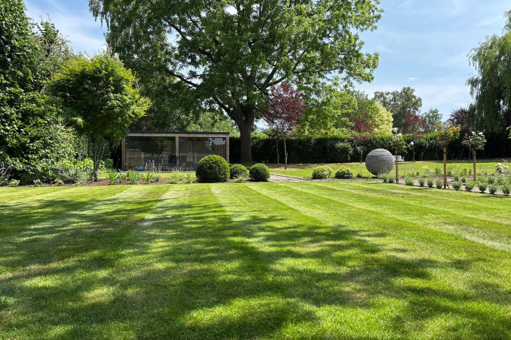 Are garden rooms a good investment? A garden room with glass sliding doors, set in a modern country garden in England.